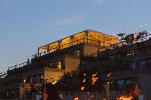 A bonfire glows on the sand at dusk at Gurney's Montauk Resort